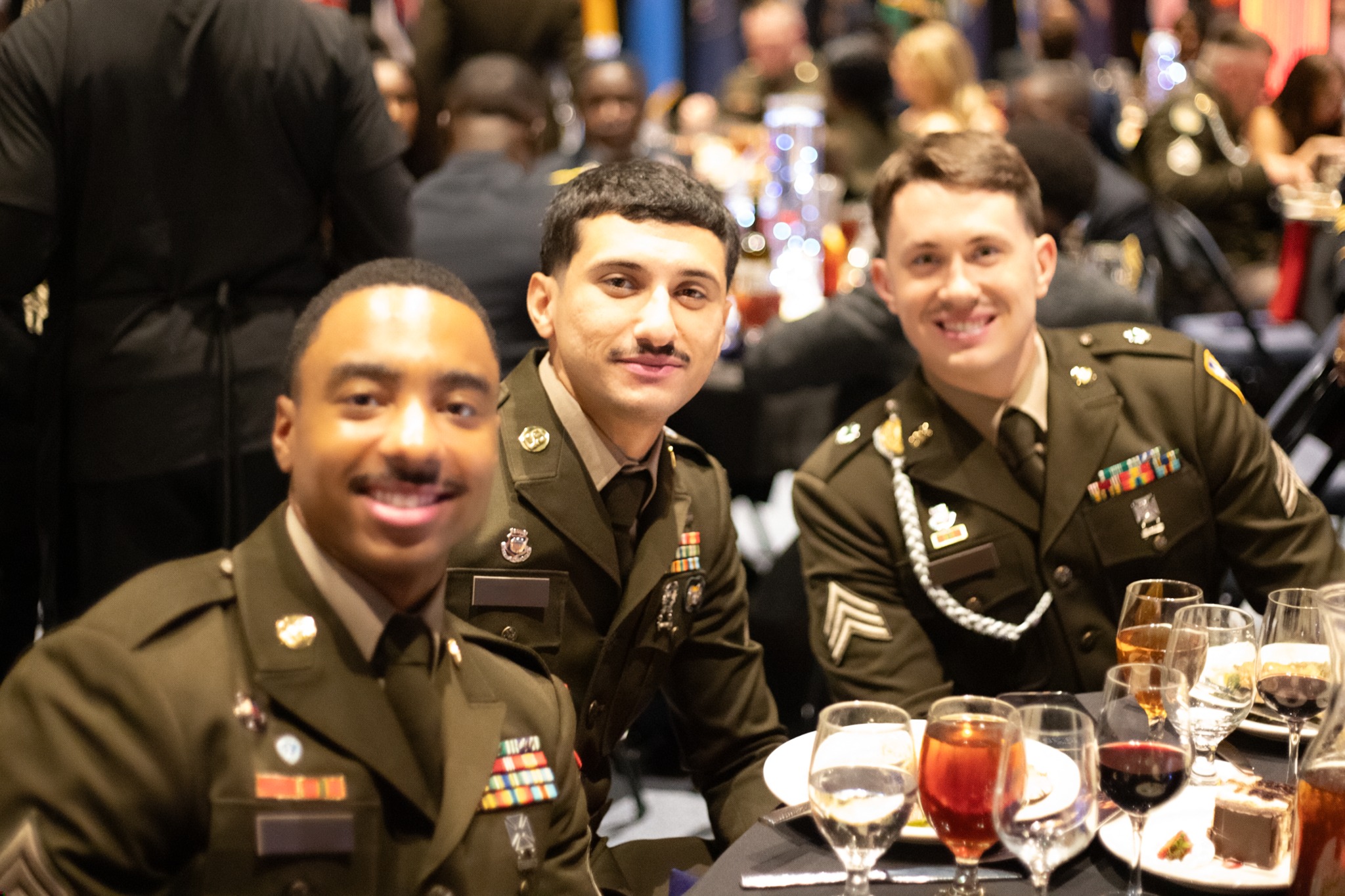 Three service members together at a banquet table